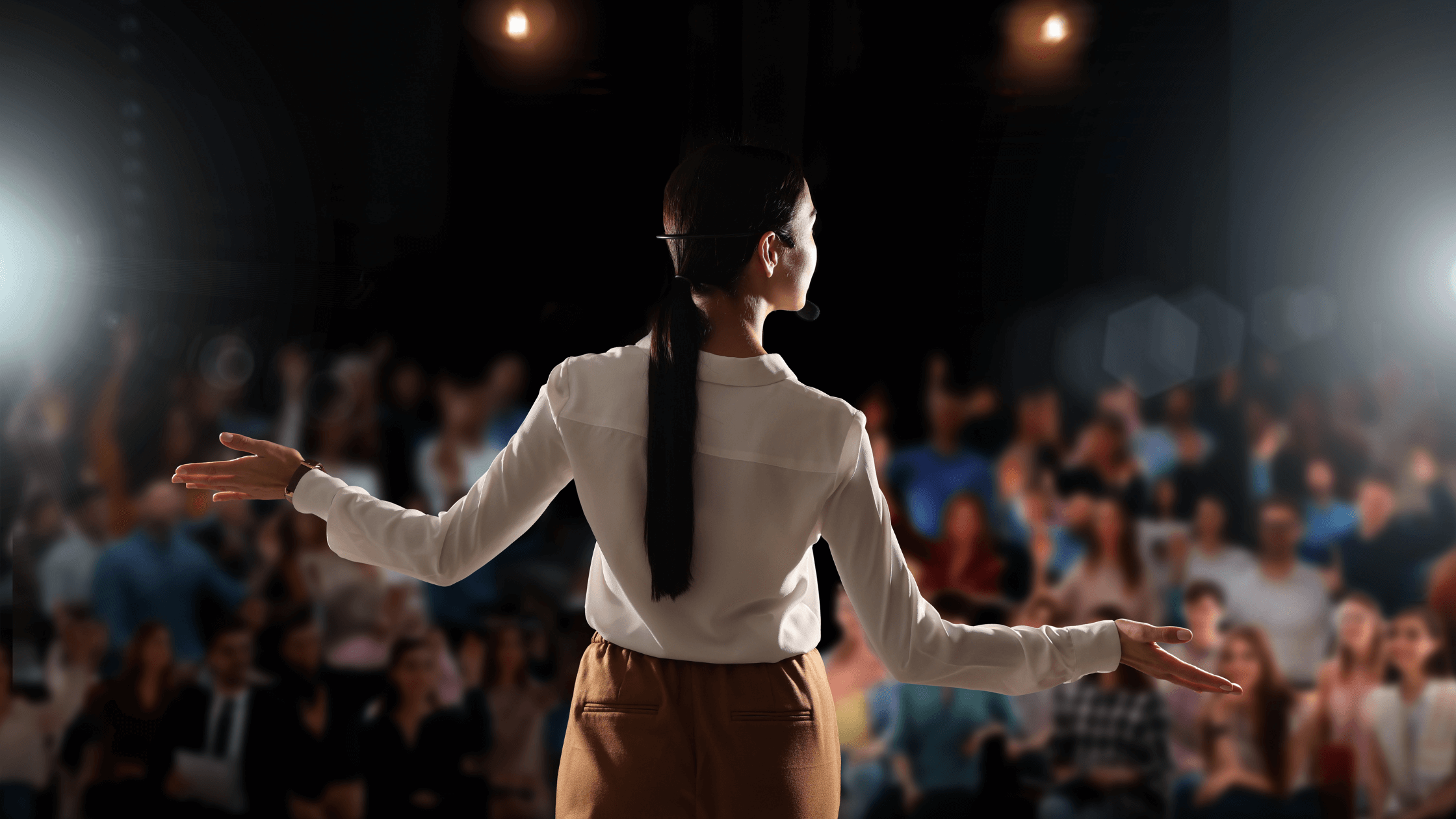 Mulher fazendo palestra para auditório com pessoas